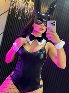 Vista frontal del disfraz de conejita negra con antifaz, body brillante y accesorios blancos con corbatín negro.